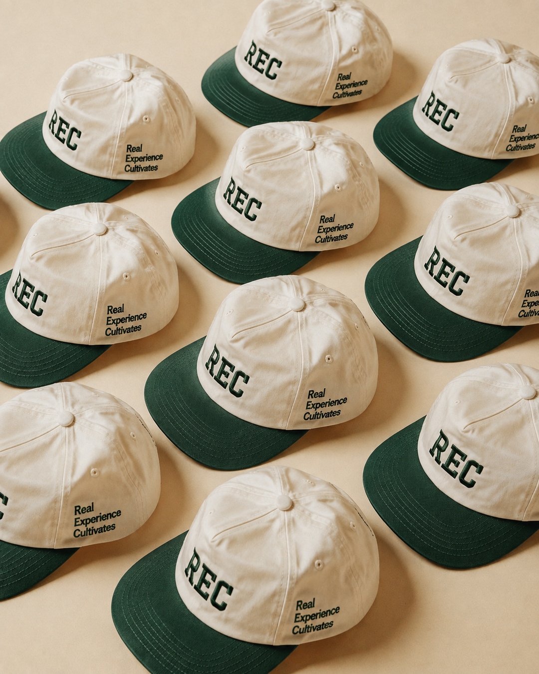 Grid of cream and green REC two-tone caps — expression at scale