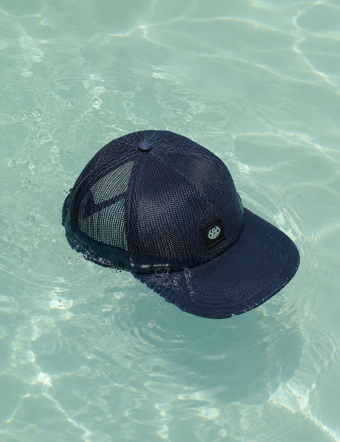 Navy mesh cap floating in water — quick-dry construction